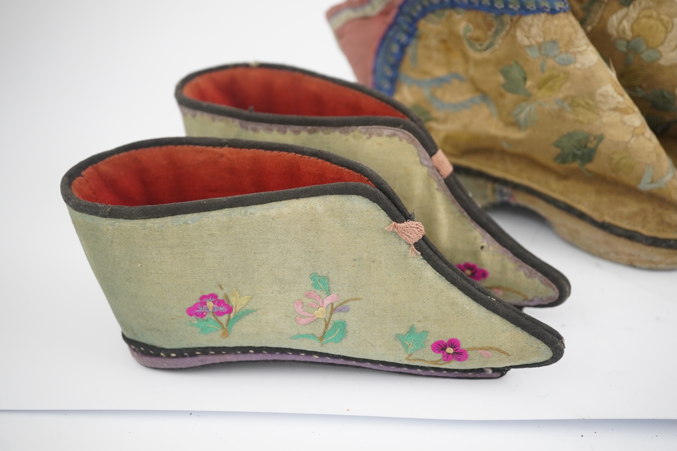 Three pairs of late 19th / early 20th century Chinese ladies embroidered silk shoes, for bound feet, one with sheep’s wool pom-poms, together with a similar a pair of silk embroidered ankle boots and pair of decorative r